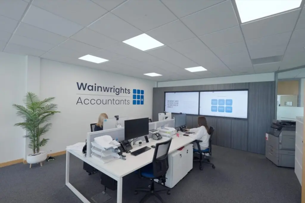 Two members of the Wainwrights Accountants team at their desks in the Bromborough office