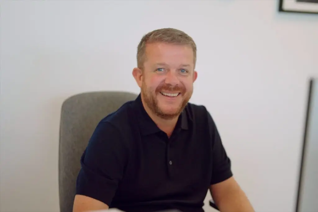 A member of the Wainwrights Accountants team smiling at his desk in the Bromborough office