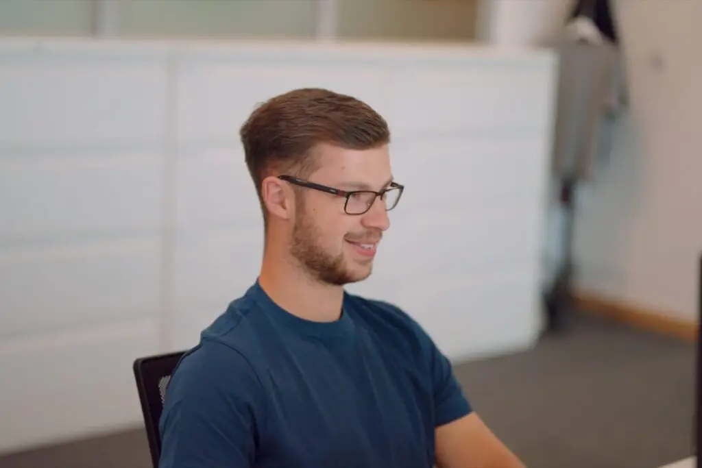 A Wainwrights accountant in glasses working at his computer in the Bromborough office