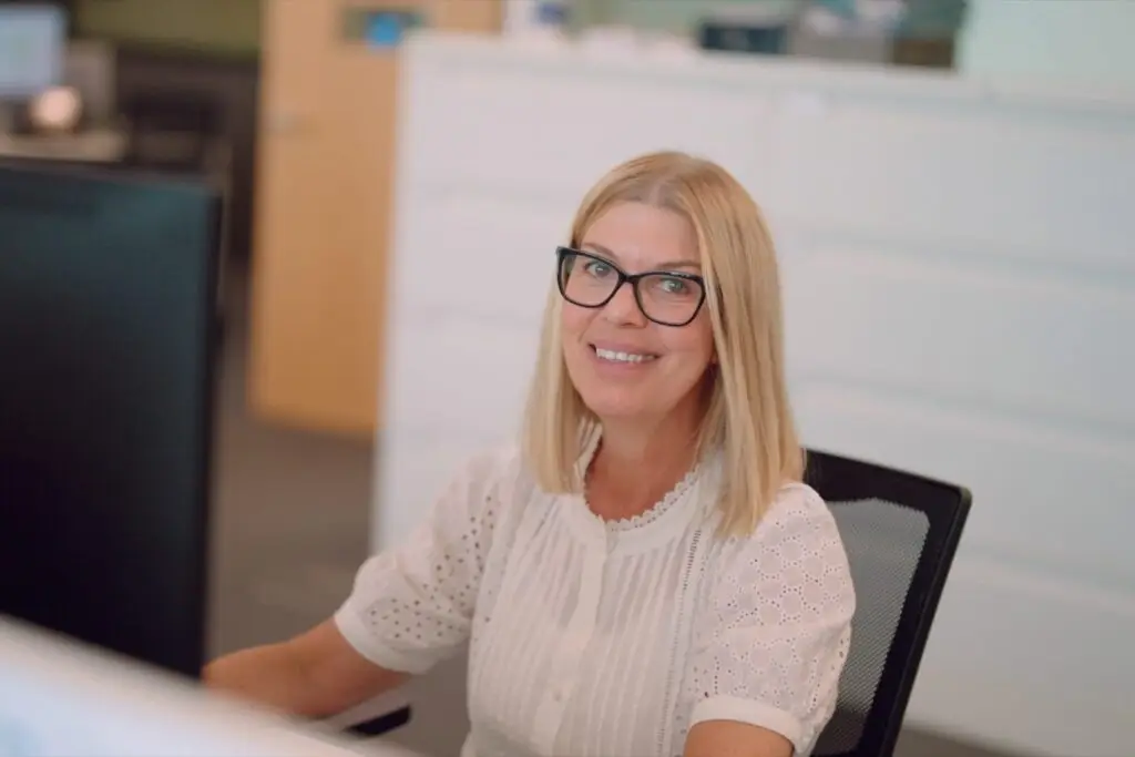 A member of the Wainwrights Accountants team smiling at her desk in the Bromborough office