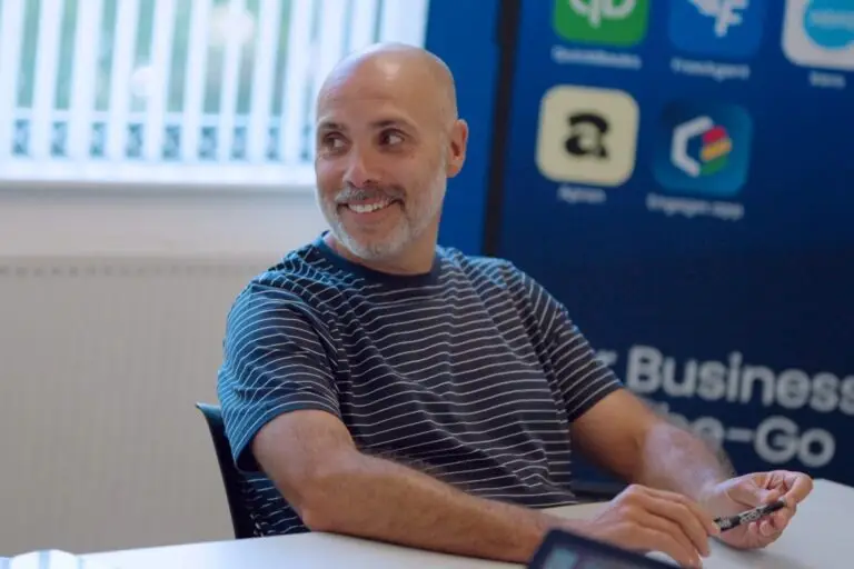A Wainwrights accountant smiling across the meeting room table, pen in hand