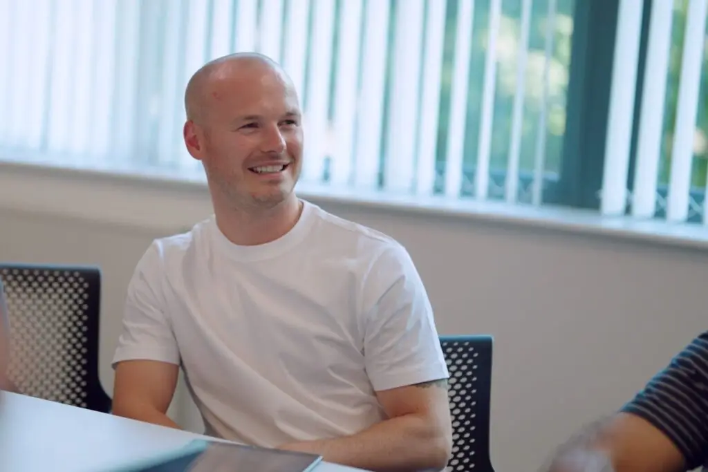 A member of the Wainwrights Accountants team smiling as he listens in a meeting