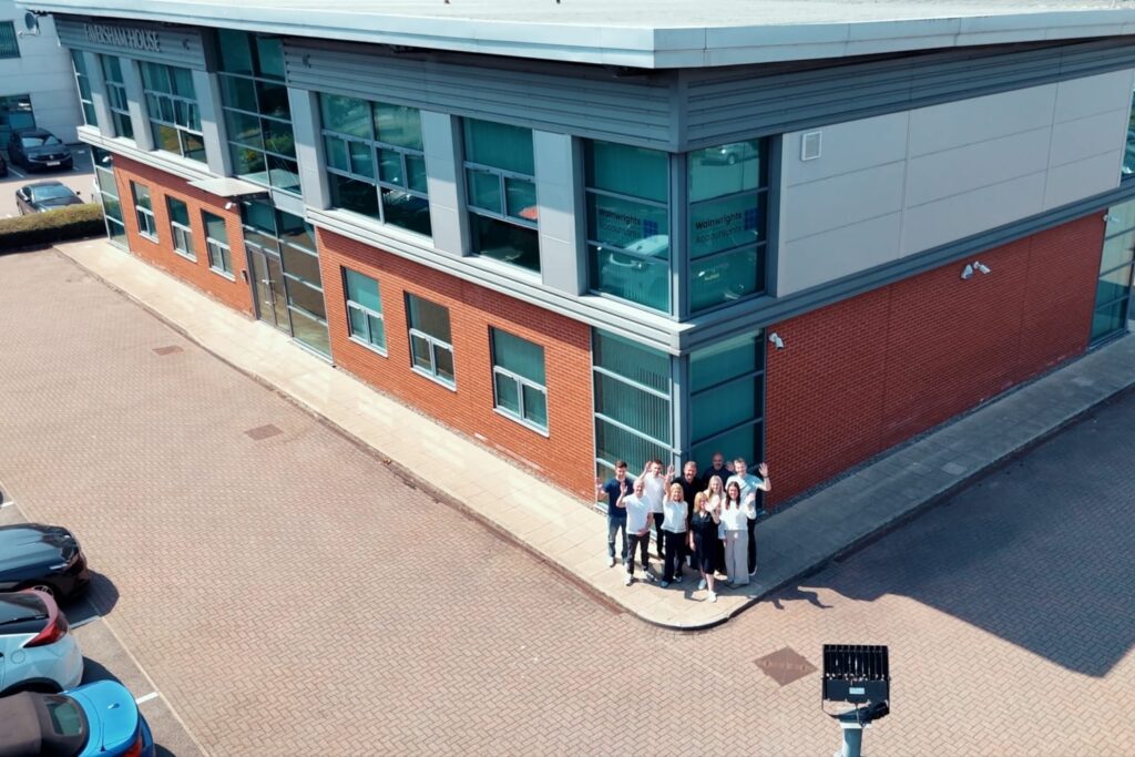 The Wainwrights Accountants team waving from outside their office at Faversham House, Bromborough